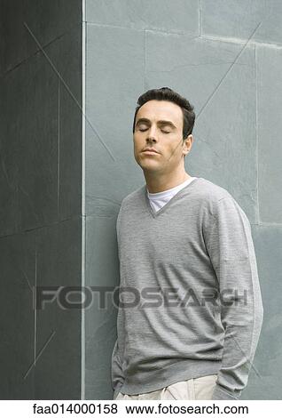 Man leaning against wall, closing eyes View Large Photo Image Stock Photo - Man leaning against wall, closing eyes. Fotosearch