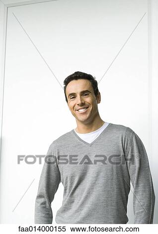Stock Photography - Man smiling, waist up, looking at camera, portrait. Fotosearch