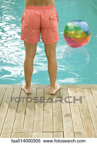 Man standing by edge of swimming pool, waist down View Large Photo Image Stock Photography - Man standing by edge of swimming pool, waist down. Fotosearch