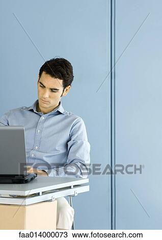 Man using laptop at desk View Large Photo Image Stock Image - Man using laptop at desk. Fotosearch