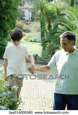 Mature man holding boys hand as he walks on ledge View Large Photo Image Stock Image - Mature man holding boys hand as he walks on ledge. Fotosearch