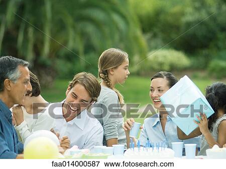 Outdoor birthday party, girl holding up present View Large Photo Image Stock Photo - Outdoor birthday party, girl holding up present. Fotosearch