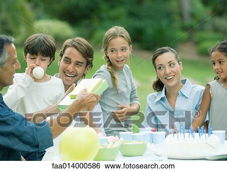 Outdoor birthday party, mature man handing girl presents View Large Photo Image Stock Photograph - Outdoor birthday party, mature man handing girl presents. Fotosearch