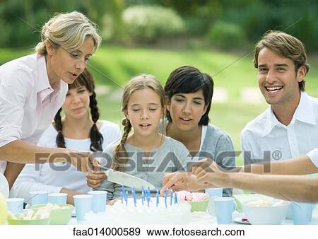 Outdoor birthday party, mature woman cutting birthday cake View Large Photo Image Stock Photo - Outdoor birthday party, mature woman cutting birthday cake. Fotosearch