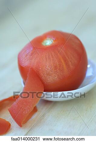 Stock Image - Partially peeled tomato. Fotosearch