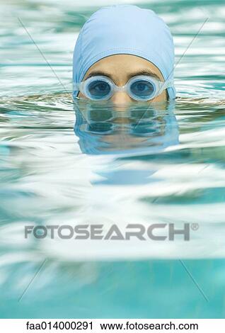 Person emerging from pool water wearing bathing cap and goggles View Large Photo Image Stock Image - Person emerging from pool water wearing bathing cap and goggles. Fotosearch