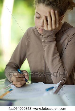 Preteen girl doing homework, holding head View Large Photo Image Stock Photo - Preteen girl doing homework, holding head. Fotosearch