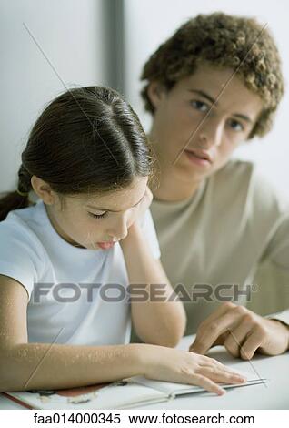Teenage boy helping younger sister with homework View Large Photo Image Stock Photography - Teenage boy helping younger sister with homework. Fotosearch