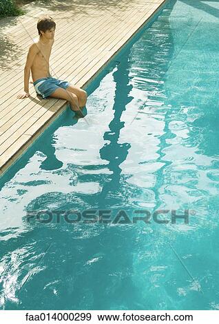 Teenage boy sitting on edge of swimming pool View Large Photo Image Stock Photo - Teenage boy sitting on edge of swimming pool. Fotosearch