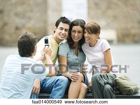 Teenage boy taking photo of friends with cell phone View Large Photo Image Stock Photo - Teenage boy taking photo of friends with cell phone. Fotosearch