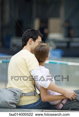 Teenage couple sitting outdoors, girl leaning against boy View Large Photo Image Stock Image - Teenage couple sitting outdoors, girl leaning against boy. Fotosearch