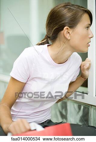 Teenage girl looking into shop window View Large Photo Image Picture - Teenage girl looking into shop window. Fotosearch