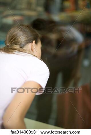 Teenage girl looking into shop window View Large Photo Image Stock Image - Teenage girl looking into shop window. Fotosearch