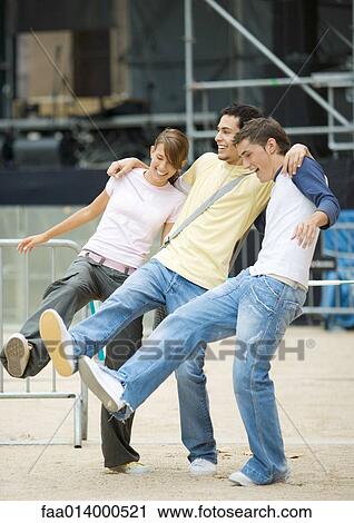 Three teenagers standing with arms around each others' shoulders and legs out View Large Photo Image Stock Image - Three teenagers standing with arms around each others' shoulders and legs out. Fotosearch