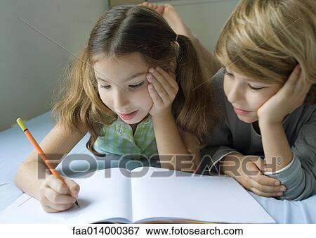 Two children doing homework together View Large Photo Image Stock Photo - Two children doing homework together. Fotosearch