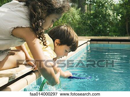 Two children leaning over edge of swimming pool View Large Photo Image Stock Photo - Two children leaning over edge of swimming pool. Fotosearch