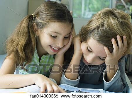 Two children looking at book together View Large Photo Image Stock Photography - Two children looking at book together. Fotosearch
