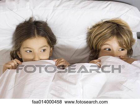 Two children lying in bed with cover pulled up to noses View Large Photo Image Stock Photo - Two children lying in bed with cover pulled up to noses. Fotosearch