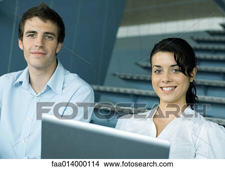 Two colleagues on stairs, with laptop, smiling View Large Photo Image Picture - Two colleagues on stairs, with laptop, smiling. Fotosearch