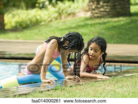 Two girls leaning on edge of pool, talking View Large Photo Image Stock Image - Two girls leaning on edge of pool, talking. Fotosearch
