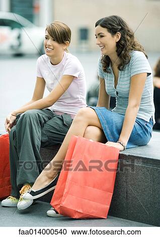 Two teenage girls sitting on bench with shopping bags View Large Photo Image Stock Image - Two teenage girls sitting on bench with shopping bags. Fotosearch
