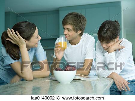 Woman and adolescent children standing in kitchen together, talking View Large Photo Image Stock Photo - Woman and adolescent children standing in kitchen together, talking. Fotosearch