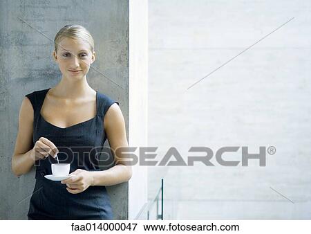 Stock Photo - Woman holding coffee cup, portrait. Fotosearch