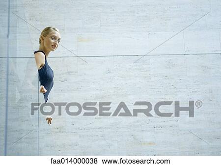 Stock Photo - Woman looking over glass guard rail, low angle view. Fotosearch