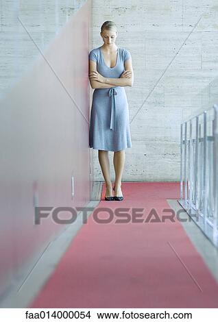 Woman standing, leaning against wall, head down, full length portrait View Large Photo Image Picture - Woman standing, leaning against wall, head down, full length portrait. Fotosearch