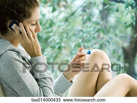 Woman using cell phone, looking at thermometer View Large Photo Image Stock Image - Woman using cell phone, looking at thermometer. Fotosearch