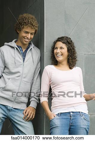 Young man and woman, leaning against corner of wall, laughing View Large Photo Image Stock Image - Young man and woman, leaning against corner of wall, laughing. Fotosearch