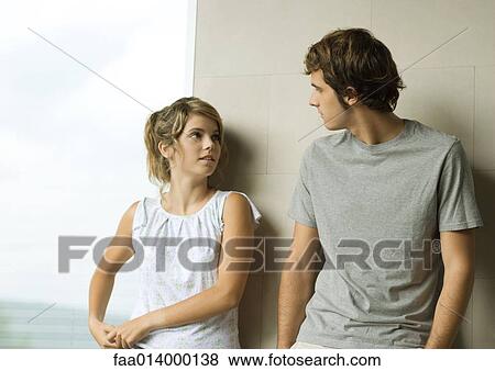 Young man and woman leaning against wall View Large Photo Image Stock Photo - Young man and woman leaning against wall. Fotosearch