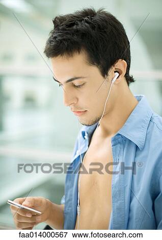 Stock Photo - Young man listening to MP3 player. Fotosearch