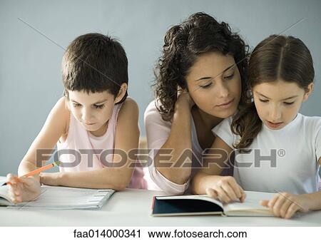 Young woman helping children with homework View Large Photo Image Stock Image - Young woman helping children with homework . Fotosearch
