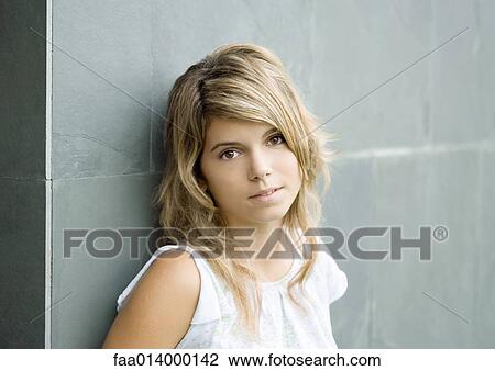Young woman leaning against wall, portrait View Large Photo Image Stock Image - Young woman leaning against wall, portrait. Fotosearch