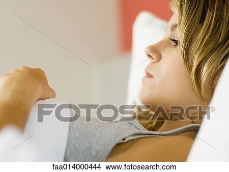 Young woman lying in bed View Large Photo Image Picture - Young woman lying in bed. Fotosearch