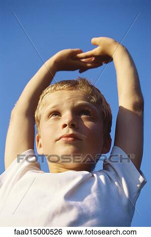 Stock Photograph - Boy stretching arms above head. Fotosearch