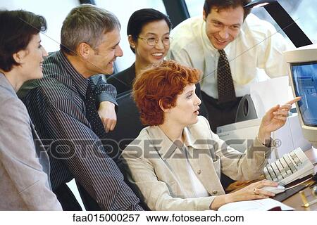Business associates grouped around computer View Large Photo Image Stock Photo - Business associates grouped around computer. Fotosearch