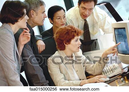 Business associates grouped around computer View Large Photo Image Stock Photograph - Business associates grouped around computer. Fotosearch