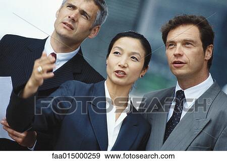 Stock Photo - Business associates, woman in foreground gesturing. Fotosearch