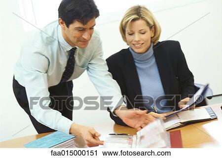 Business colleagues, man leaning over woman's shoulder View Large Photo Image Stock Image - Business colleagues, man leaning over woman's shoulder. Fotosearch