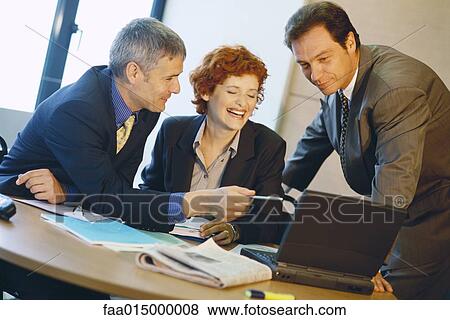 Business colleagues using laptop, laughing View Large Photo Image Stock Photo - Business colleagues using laptop, laughing. Fotosearch