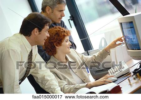 Business colleagues working at desktop computer together View Large Photo Image Stock Photo - Business colleagues working at desktop computer together. Fotosearch