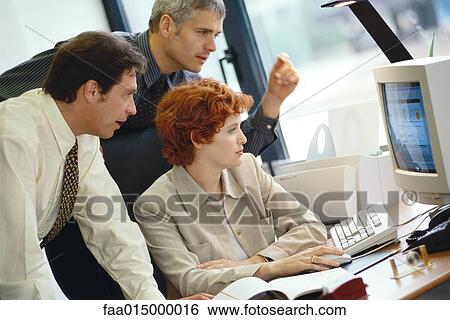 Stock Photograph - Business colleagues working at desktop computer together. Fotosearch