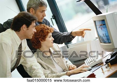 Business colleagues working at desktop computer together View Large Photo Image Stock Photography - Business colleagues working at desktop computer together. Fotosearch