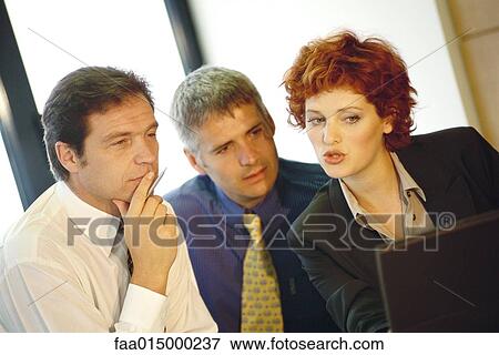 Business executives interacting around computer View Large Photo Image Stock Photo - Business executives interacting around computer. Fotosearch