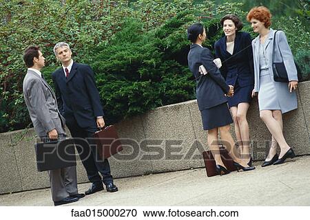 Business executives standing outdoors in groups, chatting View Large Photo Image Stock Image - Business executives standing outdoors in groups, chatting. Fotosearch