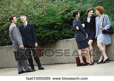 Business executives standing outdoors in groups, chatting View Large Photo Image Stock Photo - Business executives standing outdoors in groups, chatting. Fotosearch