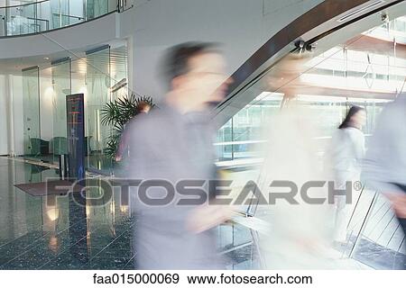 Stock Photo - Business executives walking in lobby, blurred motion. Fotosearch