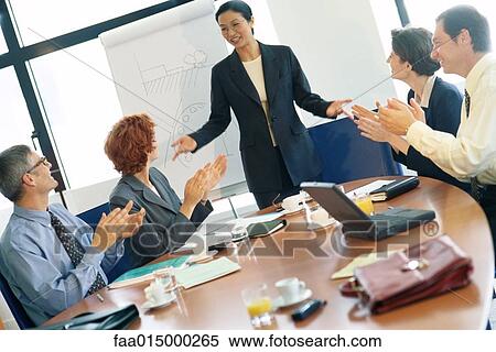 Business meeting, woman standing while colleagues clap View Large Photo Image Stock Photography - Business meeting, woman standing while colleagues clap. Fotosearch